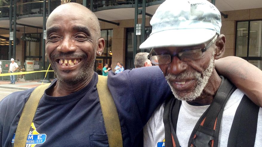 Jorge Gomez, left, and Willis Everidge are all smiles after being rescued Friday morning, April 25, 2014 from a dangling, broken scaffolding they from which they were washing windows at the Capital One building in downtown New Orleans. They hung outside the 48th floor for about ten minutes before a window was broken to pull them in. St. Charles Avenue was closed at Canal Street for emergency responders until the window washers were brought to safety. (AP Photo/ NOLA.com / The Times-Picayune, Doug MacCash)