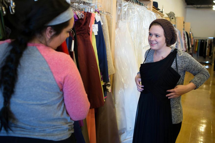 ADVANCE FOR RELEASE SATURDAY, APRIL 26, 2014, AND THEREAFTER - In this April 9, 2014 photo, Katelyn McDaniel, right, asks for her friend Rhea Losano's opinion about a dress to possibly wear to prom at Second Debut, the Goodwill's boutique store, at the Goodwill store in St. Louis Park, Minn. Sales at the thrift stores of Goodwill-Easter Seals Minnesota have soared thanks to a surge in the opening of new stores beyond the urban core, according to the Minnesota Public Radio. (AP Photo/Minnesota Public Radio, Jennifer Simonson)