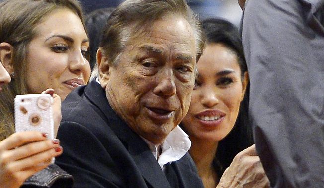 In this photo taken on Friday, Oct. 25, 2013, Los Angeles Clippers owner Donald Sterling, center, and V. Stiviano, right, watch the Clippers play the Sacramento Kings during the first half of an NBA basketball game, in Los Angeles. The NBA is investigating a report of an audio recording in which a man purported to be Sterling makes racist remarks while speaking to Stiviano.  NBA spokesman Mike Bass said in a statement Saturday, April 26, 2014, that the league is in the process of authenticating the validity of the recording posted on TMZ&#x27;s website. Bass called the comments &amp;quot;disturbing and offensive.&amp;quot;  (AP Photo/Mark J. Terrill)