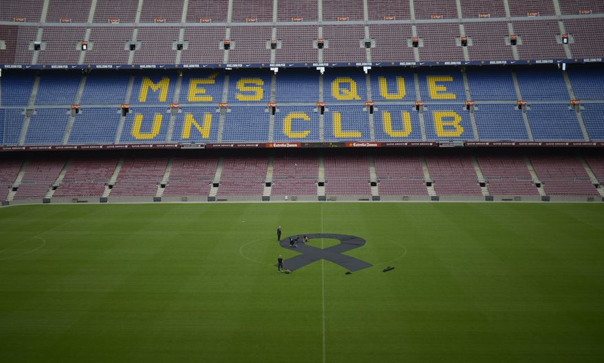 FC Barcelona's employees place a black sash mid-field in respect to late former FC Barcelona's coach Tito Vilanova at Camp Nou Stadium in Barcelona, Spain, Saturday, April 26, 2014. FC Barcelona announced on their web page Friday April 25, 2014, that Vilanova has died Friday following a long battle with throat cancer. He was 45. The sign on stands reads "More than a Club". (AP Photo/Manu Fernandez)