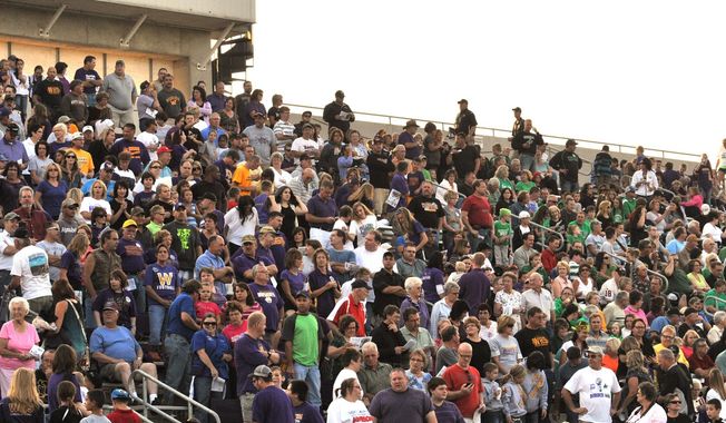 ADVANCE FOR USE SUNDAY, APRIL 27 - In this photo taken on Aug. 31, 2012, fans fill the stadium for the Harvest Bowl high school football game between Wahpeton and Breckenridge in Wahpeton, N.D. Wahpeton, N.D., and Breckenridge, Minn., High Schools have a long-standing tradition of meeting up each season for a hard-nosed game of football. But now this late-August, early-September classic is in jeopardy. (AP Photo/The Daily News)