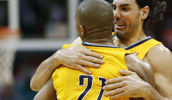 Indiana Pacers forward David West (21) celebrates with teammate Luis Scola (4) after hitting a basket late in the second half of Game 4 of an NBA basketball first-round playoff series against the Atlanta Hawks, Saturday, April 26, 2014, in Atlanta. The Pacers won 91-88 to even the series at two games apiece. (AP Photo/John Bazemore)