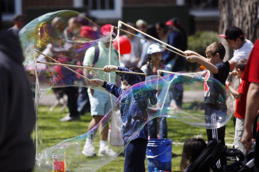 Children make huge bubbles during the Rutgers Day events in New Brunswick, N.J., Saturday, April 26, 2014. The annual event showcases hundreds of events and programs sponsored by schools, departments, institutes, centers and student organizations on the university's campuses in New Brunswick and Piscataway. (AP Photo/Mel Evans)