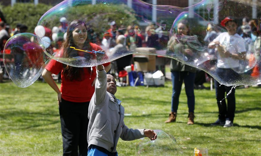 Children play with huge bubbles during the Rutgers Day events in New Brunswick, N.J., Saturday, April 26, 2014. The annual event showcases hundreds of events and programs sponsored by schools, departments, institutes, centers and student organizations on the university's campuses in New Brunswick and Piscataway. (AP Photo/Mel Evans)