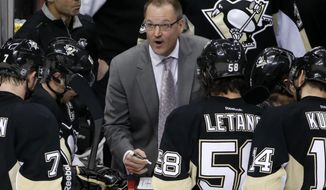 Pittsburgh Penguins&#39; coach Dan Bylsma, center, looks at the scoreboard during a timeout in the third period of Game 5 of a first-round NHL playoff hockey series against the Columbus Blue Jackets in Pittsburgh, Saturday, April 26, 2014. The Penguins won 3-1. (AP Photo/Gene J. Puskar)