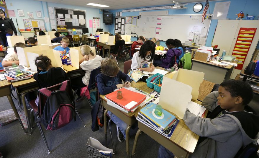 In this April 18, 2014 photo, students in a fourth-grade classroom at Olympic View Elementary School in Lacey, Wash. use upright file folders to shield their papers in crowded desk clusters during an exam. An Associated Press analysis of Washington school enrollment data shows 136 school districts, out of 295, added students between the 2011-12 school year and the current academic year. (AP Photo/Ted S. Warren)