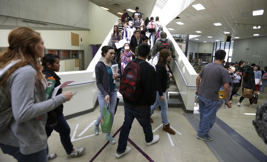 In this April 18, 2014 photo, arrows in the floor help direct foot traffic flow as students at North Thurston High School in Olympia, Wash. move into a lunch period. An Associated Press analysis of Washington school enrollment data shows 136 school districts, out of 295, added students between the 2011-12 school year and the current academic year. (AP Photo/Ted S. Warren)