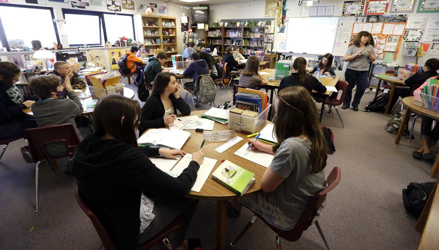 In this April 18, 2014 photo, Annette Wells, right, leads a discussion in her 7th-8th grade language arts class at Komachin Middle School in Lacey, Wash. (AP Photo/Ted S. Warren) ** FILE **