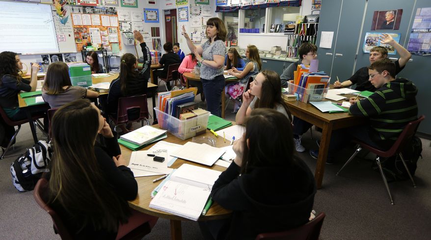 **FILE** In this April 18, 2014, photo, Annette Wells, center, takes questions in her seventh-eighth grade language arts class at Komachin Middle School in Lacey, Wash. (AP Photo/Ted S. Warren)