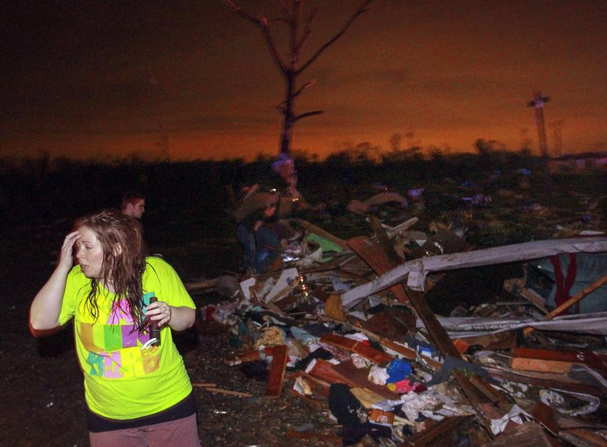 In this Sunday, April 27, 2014 photo, Lauren Watts searches for her dog in Mayflower, Ark., after a tornado struck the town. A tornado system ripped through several states in the central U.S. and left more than a dozen dead in a violent start to this year's storm season, officials said. (AP Photo/The Arkansas Democrat-Gazette, Benjamin Krain) ARKANSAS TIMES OUT; ARKANSAS BUSINESS OUT