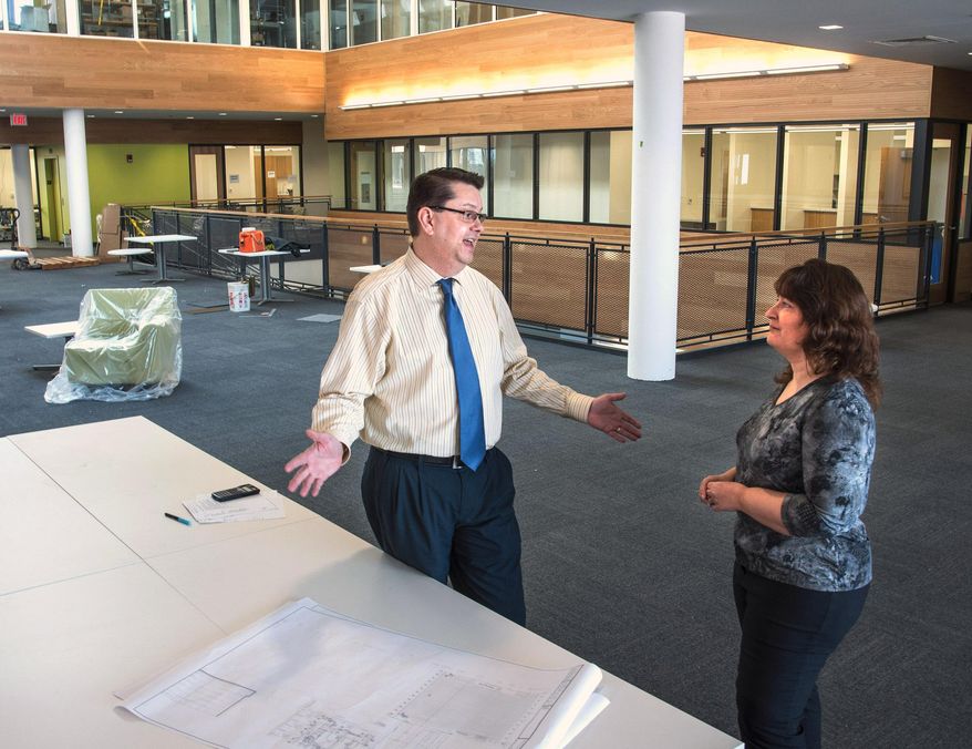 In this April 8, 2014 photo, Tim Wendt, left, director of financial aid and veteran services at Parkland College, and Kristina Taylor, coordinator of veterans and military personnel, stand outside the new Veterans Resource Center at Parkland College in Champaign, Ill. A state program that guarantees college tuition for Illinois veterans has provided less and less money in recent years. That leaves public universities and community colleges to pick up the tab, which is expected to top $32 million this year. Wendt says the school will spend $600,000 this year on Veterans Grant funding. (AP Photo/The News-Gazette, John Dixon) MANDATORY CREDIT