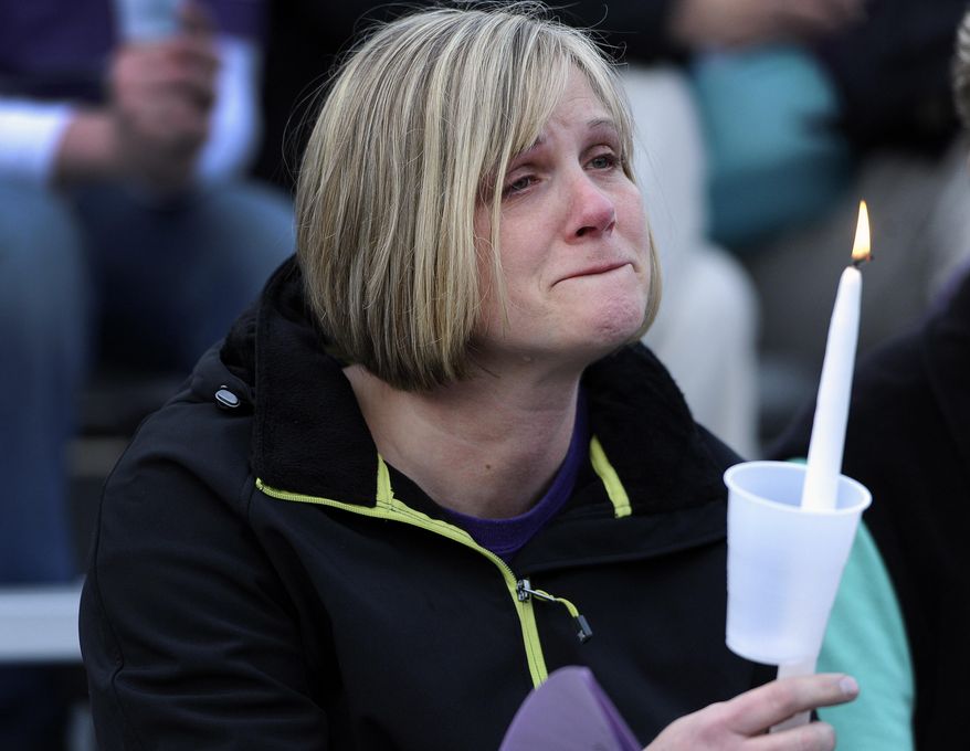 A woman cries during a vigil for Maren Sanchez at Jonathan Law High School, Monday, April 28, 2014, in Milford, Conn. Sanchez was fatally stabbed inside the school on Friday hours before her junior prom. (AP Photo/Jessica Hill)
