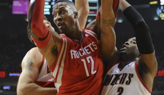 Houston Rockets&#39; Dwight Howard (12) is trapped by Portland Trail Blazers&#39; Wesley Matthews (2) and Joel Freeland during the first half of game four of an NBA basketball first-round playoff series game in Portland, Ore., Sunday March 30, 2014. (AP Photo/Greg Wahl-Stephens)