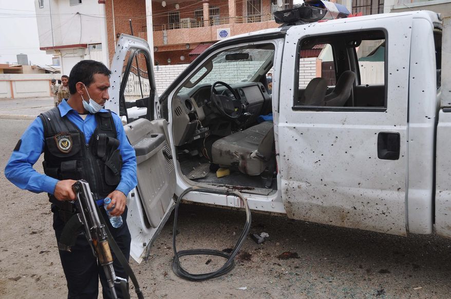 An Iraqi policeman inspects the site of a suicide attack at a polling center in Kirkuk. Officials said bombers have targeted polling centers as soldiers cast ballots.