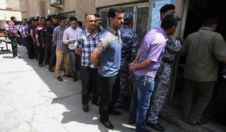 Iraqi security forces line up outside a polling center in Baghdad on Monday, two days before the civilian population votes. Despite democratic elections, Baghdad is gripped by fear and scarred by violence more than two years after the U.S. withdrawal of troops. (Associated Press photographs)