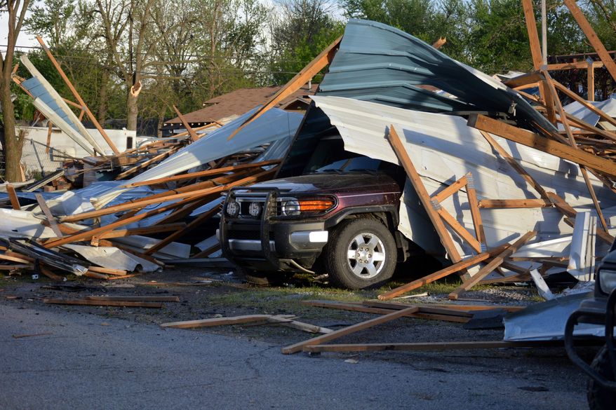 An SUV is buried under wreckage, the result of a storm that hit Quapaw, Okla., Sunday, April 27, 2014. A powerful storm system rumbled through the central and southern United States on Sunday, spawning tornados. (AP Photo/Miami News-Record/Jim Ellis