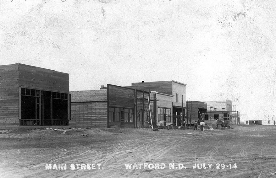 This July 29, 1914 photo provided by the Pioneer Museum of McKenzie County shows buildings on Main Street, looking north, in downtown Watford City, N.D. A century later, the town is in the epicenter of the Baaken oil boom, with a major growth in population, growing from 1,500 people to as many as 7,000 in the town and its outskirts. (AP Photo/Pioneer Museum of McKenzie County)