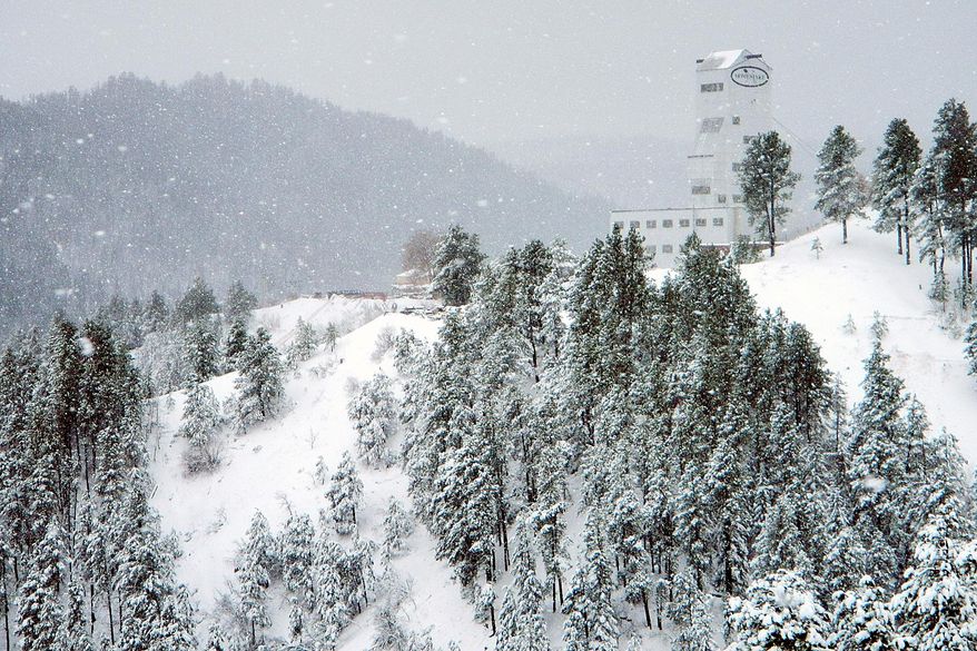 Snow falls at noon Monday, April 28, 2014, in the highest reaches of Lead, S.D., where the Ross Shaft at the Sanford Underground Research Facility stands sentinel on a pine-clad hilltop. A system that brought deadly weather to the central and southern U.S. over the weekend dumped heavy snow in western South Dakota late Sunday and early Monday. (AP Photo/Rapid City Journal, Tom Griffith)