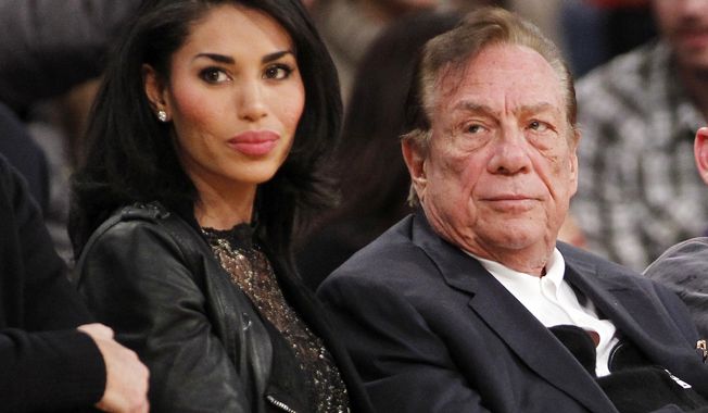 Los Angeles Clippers owner Donald Sterling and V. Stiviano watch an NBA preseason game in 2010. (AP Photo/Danny Moloshok, File)
