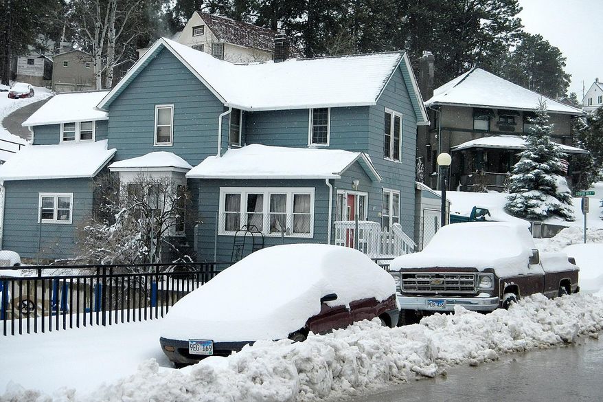 Plowed in and covered in more than a foot of new snow, vehicles in a Lead, S.D. neighborhood await the attention of their owners Monday morning, April 28, 2014. A system that brought deadly weather to the central and southern U.S. over the weekend dumped heavy snow in western South Dakota late Sunday and early Monday (AP Photo/Rapid City Journal, Tom Griffith)
