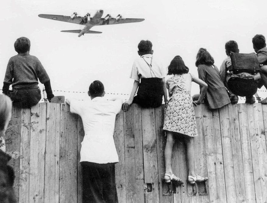 West Berlin children at Tempelhof Airport watch fleets of U.S. airplanes bringing in supplies to circumvent the Russian blockade in this undated file photo. The airlift began June 25, 1948, and continued for 11 months. (Associated Press/File)