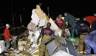 Emergency personnel search the remains of several mobile homes in Louisville, Miss., for survivors early Tuesday morning, April 29, 2014 after a tornado hit the east Mississippi community Monday.  Tornadoes flattened homes and businesses, flipped trucks over on highways and bent telephone poles into 45-degree angles as they barreled through Alabama and Mississippi on Monday, part of a storm system that killed at least nine people in the South and brought the overall death toll from two days of severe weather in the country to at least 26. (AP Photo/Rogelio V. Solis)
