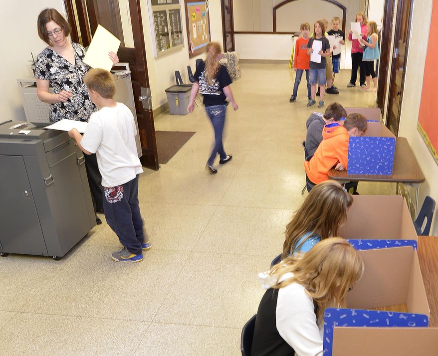 Fourth-graders mark their ballots while voting for a new school name Monday, April 28, 2014, at Washington Elementary School in Sioux City, Iowa. Students at Washington and Whittier schools were choosing between Discovery, Journey, Lewis and Morningside for a name for their new school building which will open in 2015. (AP Photo/The Sioux City Journal, Tim Hynds)