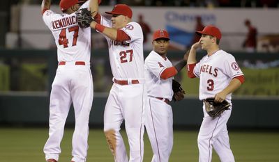 Los Angeles Angels second baseman Howie Kendrick, left, celebrates with Mike Trout, Erick Aybar and J.B. Shuck, from second from left, after the Angels defeated the Cleveland Indians 6-3 in a baseball game in Anaheim, Calif., Monday, April 28, 2014. (AP Photo/Chris Carlson)