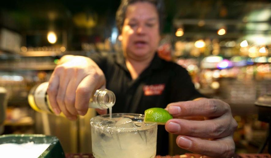In this Monday, April 28, 2014, file photo, bartender Mario Sanchez crafts a margarita cocktail at the bar of El Coyote, a Mexican restaurant in Los Angeles. (AP Photo) ** FILE **