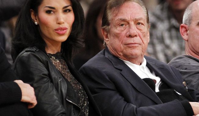 ** FILE ** In this Dec. 19, 2010, file photo, Los Angeles Clippers owner Donald Sterling, third right, sits with V. Stiviano, left, as  they watch the Clippers play the Los Angeles Lakers during an NBA preseason basketball game in Los Angeles. NBA commissioner Adam Silver announced Tuesday, April 29, 2014, that he is banning the owner for life from the Clippers organization over racist comments in recording. (AP Photo/Danny Moloshok, File)