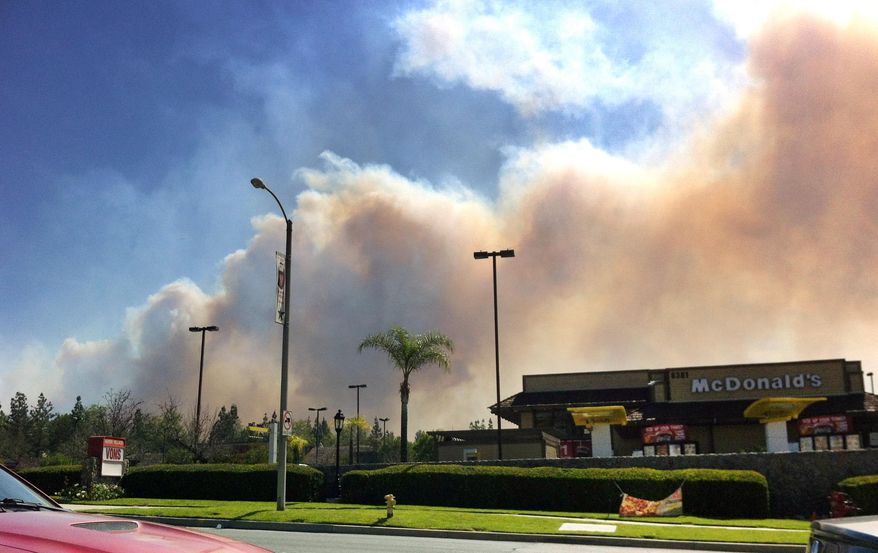 Smoke from a wildfire can bee seen in Rancho Cucamonga, Calif., Wednesday April 30, 2014. Schools and homes were evacuated Wednesday, as dry, gusty winds fanned a smoky wildfire in the foothills of the San Bernardino Mountains in California. At least three schools were shut down due to the smoky conditions in parts of Rancho Cucamonga, a city of 165,000 people east of Los Angeles. (AP photo/John Antczak)