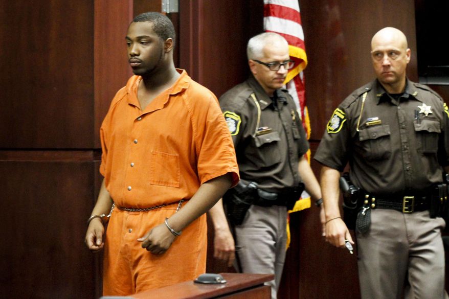 Shundarius Lawson, is escorted into Muskegon County District Judge Michael J. Nolan's courtroom for an arraignment on Wednesday, April 30, 2014 in Muskegon, Mich. Muskegon County Prosecutor D.J. Hilson says Lawson, 20, was in a sport utility vehicle from which shots were fired that killed 17-year-old Marquis Gresham on April 23. According to Hilson, the investigation is continuing, and more charges against others are possible. Gresham was a junior and a starting center on the Muskegon Heights Public School Academy team that advanced to the state semifinals. (AP Photo/The Muskegon Chronicle, Madelyn Hastings) ALL LOCAL TV OUT; LOCAL TV INTERNET OUT