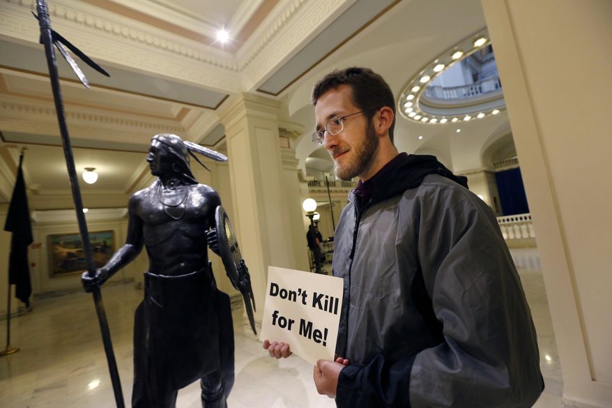 Sam Jennings with Oklahoma Coalition Against the Death Penalty holds a sign protesting the death penalty at the State Capitol in Oklahoma City, Tuesday April 29, 2014. Oklahoma prison officials halted the execution of an inmate after the delivery of a new three-drug combination on Tuesday failed to go as planned. (AP Photo/The Oklahoman, Steve Gooch)