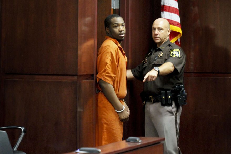 Muskegon County Sheriff's Deputy Timothy LaVigne escorts Shundarius Lawson into Muskegon County District Judge Michael J. Nolan's courtroom for his arraignment on Wednesday, April 30, 2014 in Muskegon, Mich. Muskegon County Prosecutor D.J. Hilson says Lawson, 20, was in a sport utility vehicle from which shots were fired that killed 17-year-old Marquis Gresham on April 23. According to Hilson, the investigation is continuing, and more charges against others are possible. Gresham was a junior and a starting center on the Muskegon Heights Public School Academy team that advanced to the state semifinals. (AP Photo/The Muskegon Chronicle, Madelyn Hastings) ALL LOCAL TV OUT; LOCAL TV INTERNET OUT