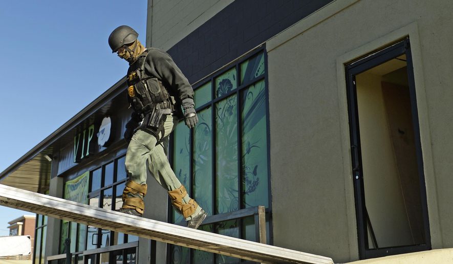 Drug Enforcement Agency officials raid a medical marijuana dispensary in Denver in this Wednesday, April 30, 2014, file photo. (AP Photo/The Denver Post, RJ Sangosti) ** FILE **