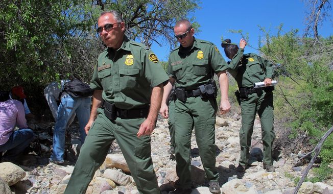 ** FILE ** U.S. Border Patrol Tucson Sector Chief Manuel Padilla, left front, walks with other agents and media during a tour in the Buenos Aires National Wildlife Refuge, Wednesday, April 30, 2014, near Sasabe, Ariz. Padilla and other Border Patrol officials spent the day discussing the dangers for immigrants trying to cross the border illegally from Mexico into the U.S. (AP Photo/Brian  Skoloff)
