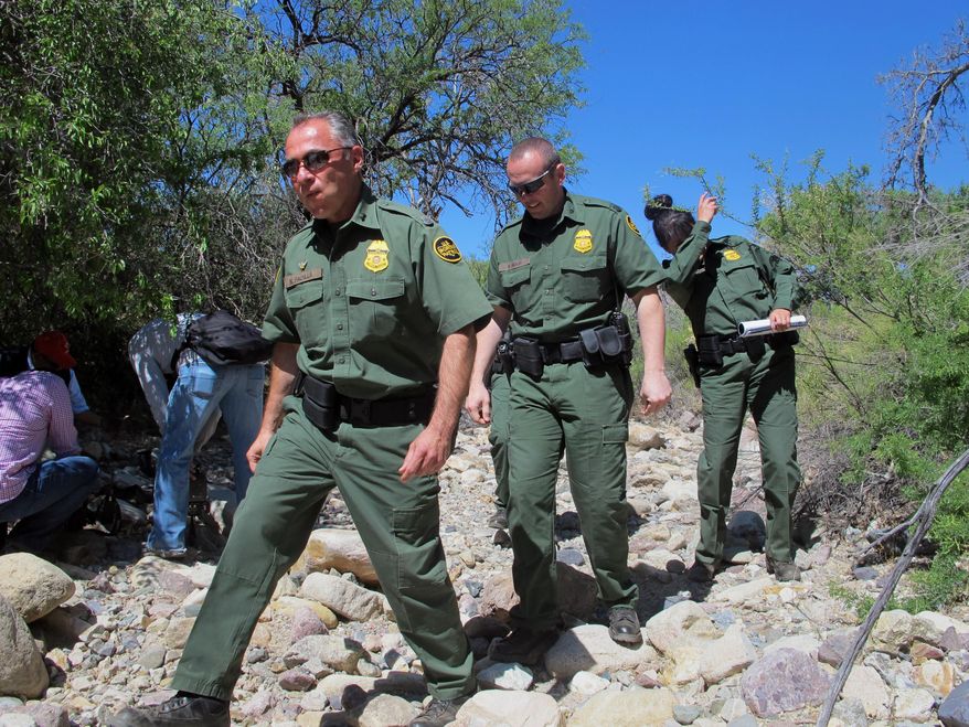 ** FILE ** U.S. Border Patrol Tucson Sector Chief Manuel Padilla, left front, walks with other agents and media during a tour in the Buenos Aires National Wildlife Refuge, Wednesday, April 30, 2014, near Sasabe, Ariz. Padilla and other Border Patrol officials spent the day discussing the dangers for immigrants trying to cross the border illegally from Mexico into the U.S. (AP Photo/Brian Skoloff)
