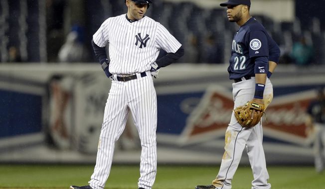 New York Yankees&#x27; Derek Jeter talks to Seattle Mariners second baseman Robinson Cano during the eighth inning of a baseball game Tuesday, April 29, 2014, in New York. (AP Photo)