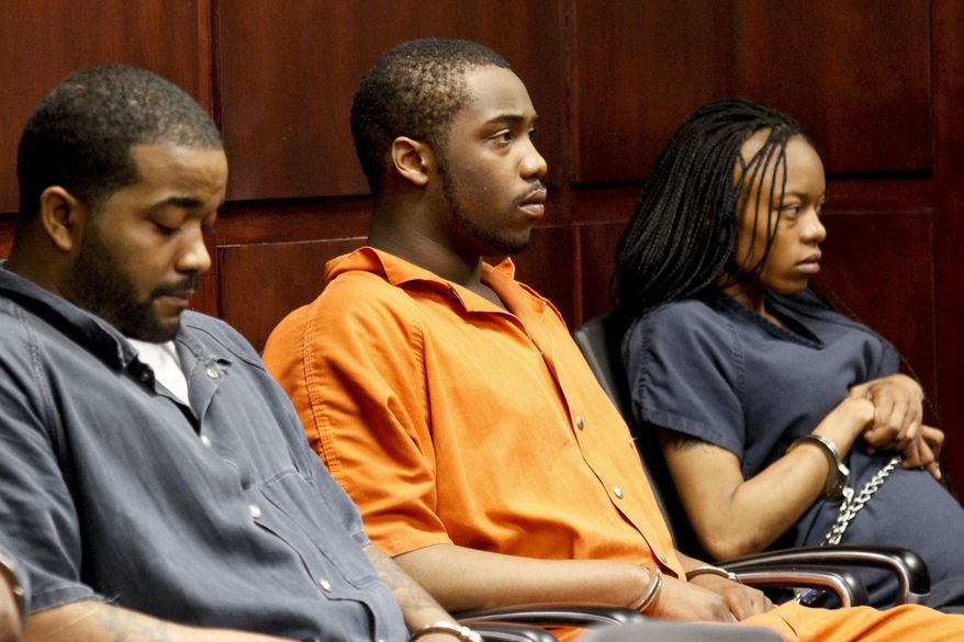 Shundarius Lawson, center, sits in Muskegon County District Judge Michael J. Nolan's courtroom for an arraignment on Wednesday, April 30, 2014 in Muskegon, Mich. Muskegon County Prosecutor D.J. Hilson says Lawson, 20, was in a sport utility vehicle from which shots were fired that killed 17-year-old Marquis Gresham on April 23. According to Hilson, the investigation is continuing, and more charges against others are possible. Gresham was a junior and a starting center on the Muskegon Heights Public School Academy team that advanced to the state semifinals. (AP Photo/The Muskegon Chronicle, Madelyn Hastings) ALL LOCAL TV OUT; LOCAL TV INTERNET OUT
