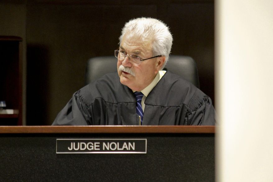 Muskegon County District Judge Michael J. Nolan talks to Shundarius Lawson, 20 during an arraignment on Wednesday, April 30, 2014 in Muskegon, Mich. Muskegon County Prosecutor D.J. Hilson says Lawson, 20, was in a sport utility vehicle from which shots were fired that killed 17-year-old Marquis Gresham on April 23. According to Hilson, the investigation is continuing, and more charges against others are possible. Gresham was a junior and a starting center on the Muskegon Heights Public School Academy team that advanced to the state semifinals. (AP Photo/The Muskegon Chronicle, Madelyn Hastings) ALL LOCAL TV OUT; LOCAL TV INTERNET OUT