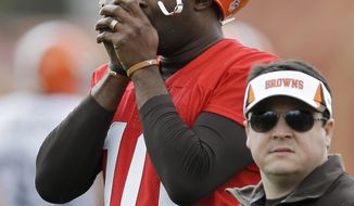 Cleveland Browns quarterback Vince Young warms his hands during a voluntary minicamp workout at the NFL football team&#39;s facility in Berea, Ohio Thursday, May 1, 2014. (AP Photo/Mark Duncan)