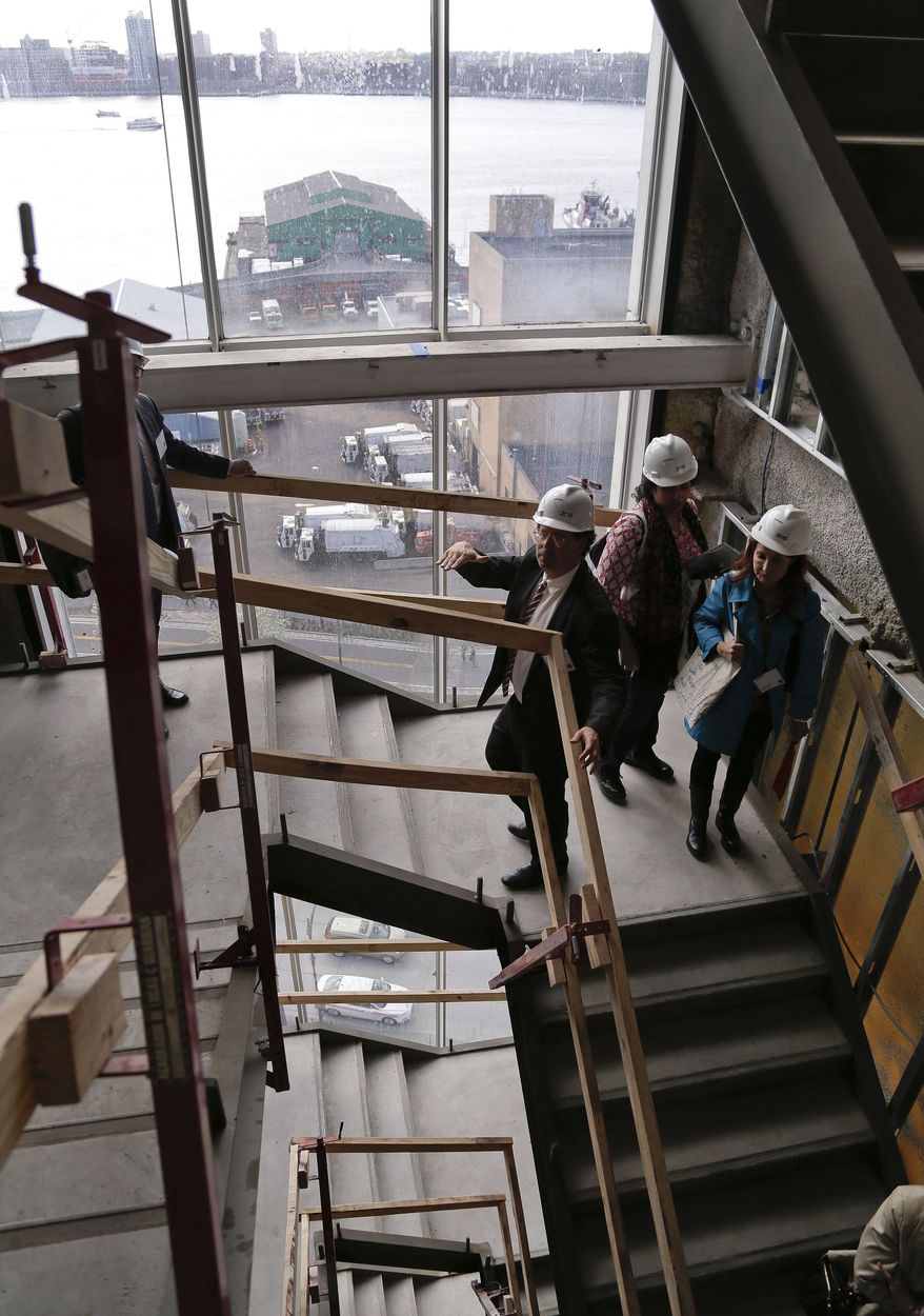 Whitney Museum director Adam Weinberg, center, explains the architectural design of a staircase during a tour of the future site for the Whitney Museum, Thursday, May 1, 2014, in New York. The museum will open in its new location in lower Manhattan in the spring of 2015. (AP Photo/Julie Jacobson)