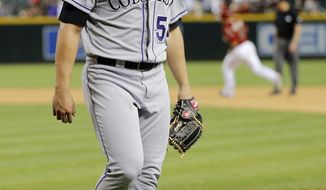 Colorado Rockies pitcher Tommy Kahnle walks off the field as Arizona Diamondbacks&#39; Miguel Montero rounds the bases after Kahnle gave up a walk off solo home run to Montero during the 10th inning of a baseball game on Wednesday, April 30, 2014, in Phoenix. The Diamondbacks won 5-4. (AP Photo/Matt York)