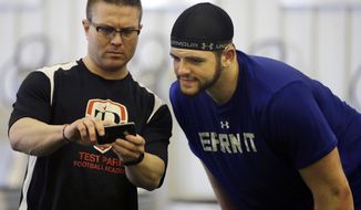 FILE - In this Friday, Feb. 14, 2014 file photo, Coach Kevin Dunn, left, goes over some techniques for the 40-yard-dash, between runs, with Gallaudet defensive lineman Adham Talaat, right, at his TEST Sports Clubs in Martinsville, N.J. Talaat has overcome being deaf to reach the doorstep of the NFL. After starring at Gallaudet University, working out at Test Parisi Football Academy and posted impressive numbers at his Pro Day, the talented defensive end is hopeful he&#39;ll get a call when the NFL draft kicks off next week. (AP Photo/Mel Evans,file)
