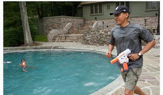 President Obama has a water gun fight with his daughter Sasha on her birthday weekend at Camp David in this June 11, 2011, file photo. (Official White House Photos by Pete Souza)  