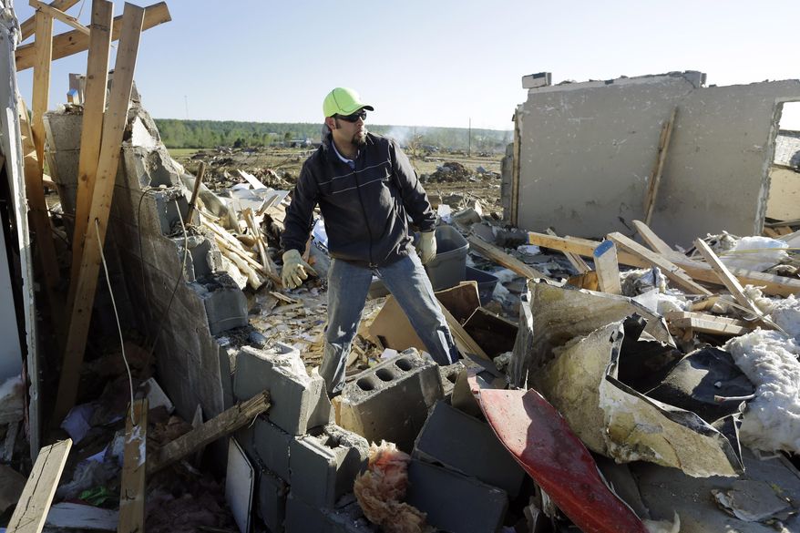 Jared Fowlkes looks through tornado wreckage at his family's business in Vilonia, Ark., Thursday, May 1, 2014. A tornado struck the town late Sunday. Sunday's storm was rated as a "high-end" EF4 on a scale of tornado strength. (AP Photo/Danny Johnston)