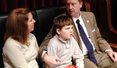 Republican Missouri Sen. Eric Schmitt, his wife Jaime Schmitt and their son Stephen Schmitt, who has epilepsy, watch state House debate in Jefferson City, Mo., on Thursday, May 1, 2014. State lawmakers sent a bill to the governor handled by Schmitt that would allow use of a cannabis extract by people whose epilepsy isn’t relieved by other treatments.
