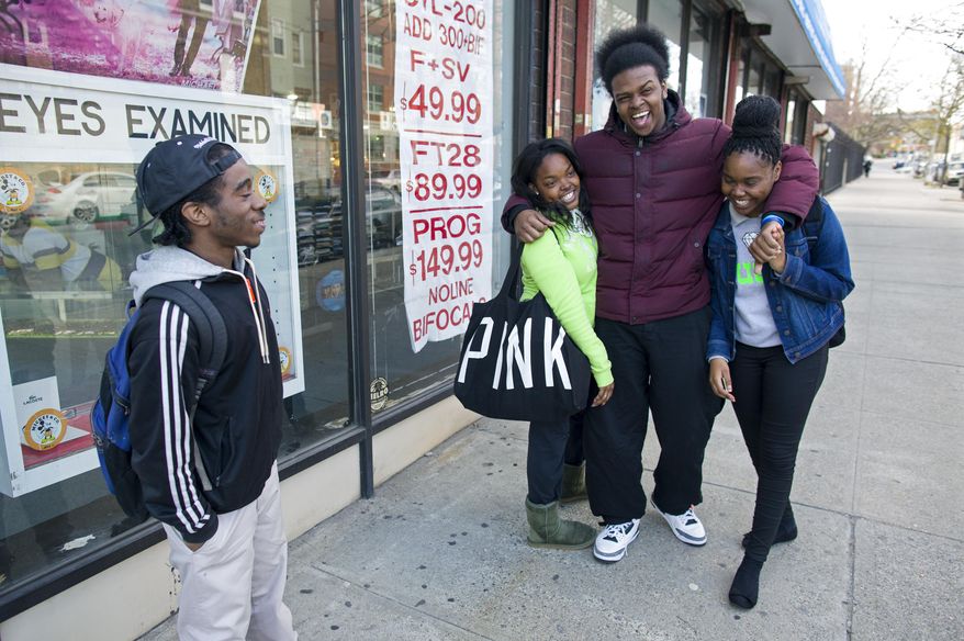 In a photograph taken Wednesday, April 23, 2014 in the Brownsville neighborhood of Brooklyn, from left, GRAAFICS student Devon Collins, 16, of East New York, stands near GTAAFICS students Tyasia Blair, 16, of East New York, Jamal Williams, 18, and Keeozel Saul, 16, after they attended an internship as part of their classwork. GRAAFICS (Gang Diversion, reentry and Absent Father Intervention Center), a program they are part of at the nearby Brooklyn Collegiate High School, is designed for individuals who have been part of a "crew," and work to stay focused on getting on with their educations and lives without being part of a neighborhood crew. (AP Photo/Craig Ruttle)