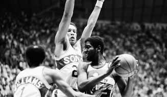 Washington Bullets Bob Dandridge (right) tries to keep the ball from the grasp of Seattle Supersonics Gus Williams (left) and John Johnson (27) during NBA Championship Game at Seattle at night on Wednesday, June 7, 1978. (AP Photo)