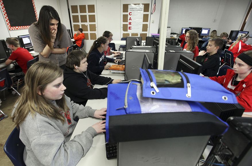 ADVANCE FOR USE SUNDAY, MAY 4 AND THEREAFTER - In this April 10, 2014 photo, Western Junior High School teacher Liz Gregor watches over her students as they work on Edgenuity, an online program that supplements classroom instruction in Kinderhook, Ill. Students move through the lesson at their own pace in the computer lab, where it’s quiet enough to hear every click of the mouse under the low murmur of conversation when a student asks a question of their teacher. The district expanded Edgenuity into all sixth- to 12th-grade classes this year and became the only one in the area to launch eSpark, a similar program for kindergarten to fifth-grade students. (AP Photo/The Quincy Herald-Whig, Steve Bohnstedt)